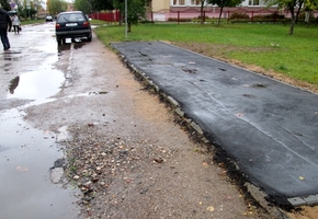 Под мусорные контейнеры уложили новый асфальт, а тротуары разбиты уже много лет